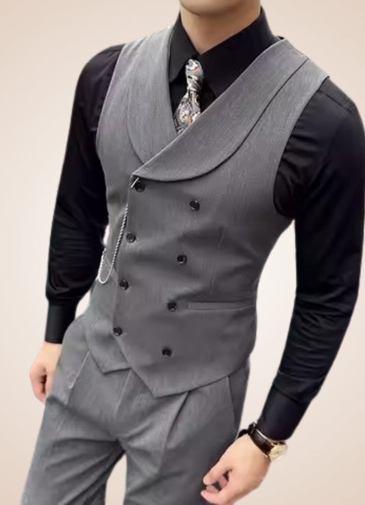 Gray vest over a black shirt with a patterned tie on a neutral background